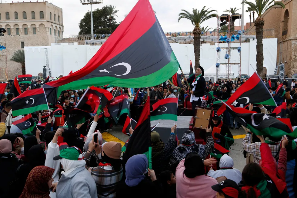 Eni focus: people wave Libyan flags earlier this year in Tripoli