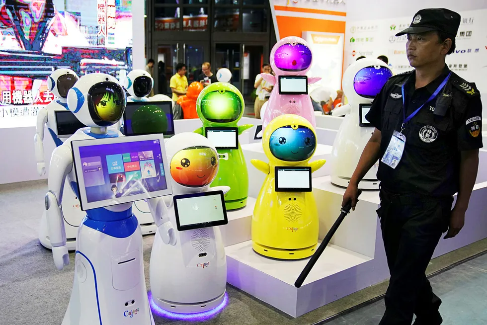 Kina satser for fullt på kunstig intelligens. På bildet passerer en sikkerhetsvakt roboter på China International Robot Show i Shanghai tidligere i juli. Foto: Aly Song/Reuters/NTB Scanpix