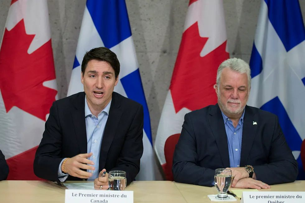 Statsminister Justin Trudeau (t.v.) under et møte med representanter for aluminiumsindustrien i Saguenay i Quebec. Delstatsminister i Quebec Philippe Couillard sitter ved hans høyre side. Foto: Jacques Boissinot / AP / NTB scanpix