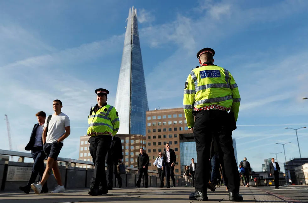 Politibetjenter patruljerer London Bridge, som mandag ble gjenåpnet etter terrorangrepet lørdag kveld. Foto: PETER NICHOLLS / REUTERS / NTB Scanpix