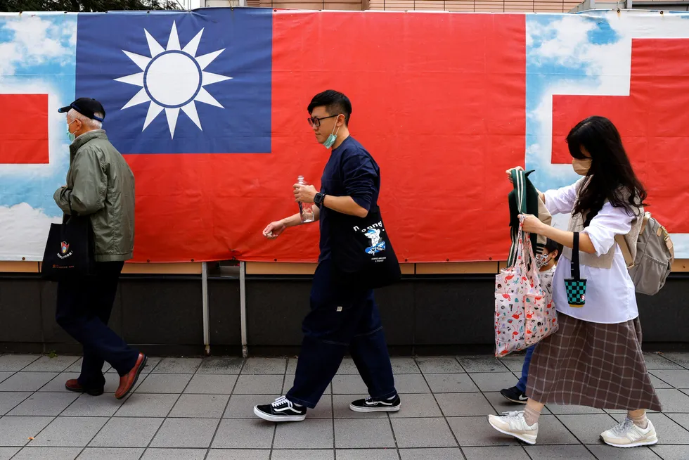Fotgjengere passerer et taiwansk flagg i Taipei.