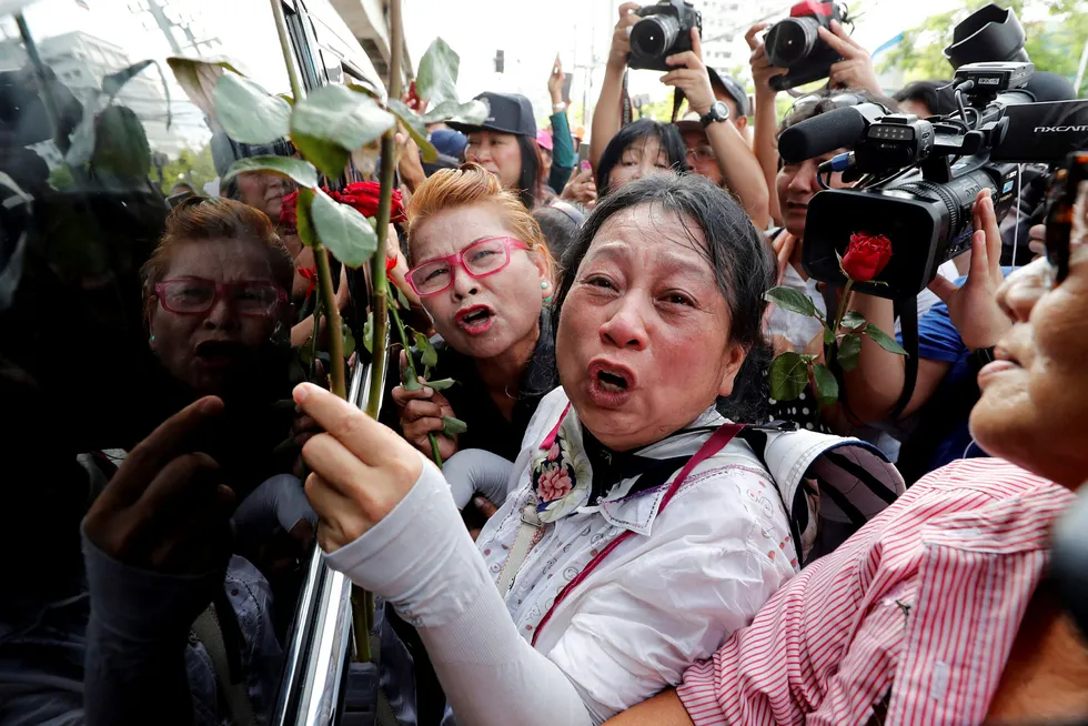 Tilhengere av den tidligere thailandske statsministeren Yingluck Shinawatra protesterer utenfor rettslokalet fredag, der hun skulle ha dukket opp. Hun kom aldri. Foto: Jorge Silva/Reuters