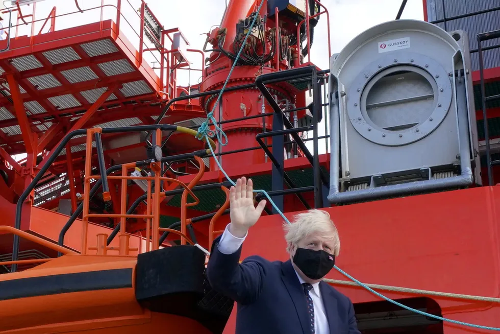 En route: UK Prime Minister Boris Johnson waves as he boards the Alba in Fraserburgh Harbour, which transported him to the Moray Offshore Windfarm East during a visit to Scotland this week.