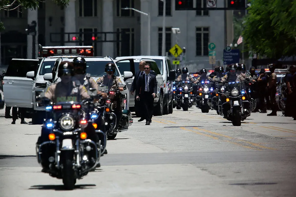 Donald Trump og motorkadesjen ankommer rettsbygningen i Miami.