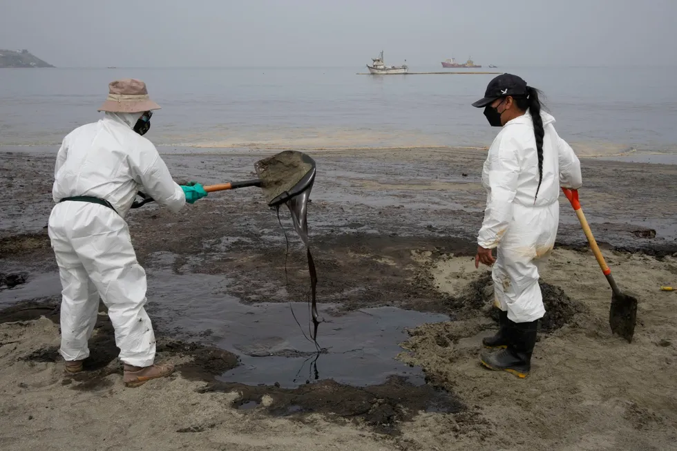 Environmental disaster: Workers, dressed in protective suits, clean the oil contaminated Conchitas Beach, in Ancon, Peru