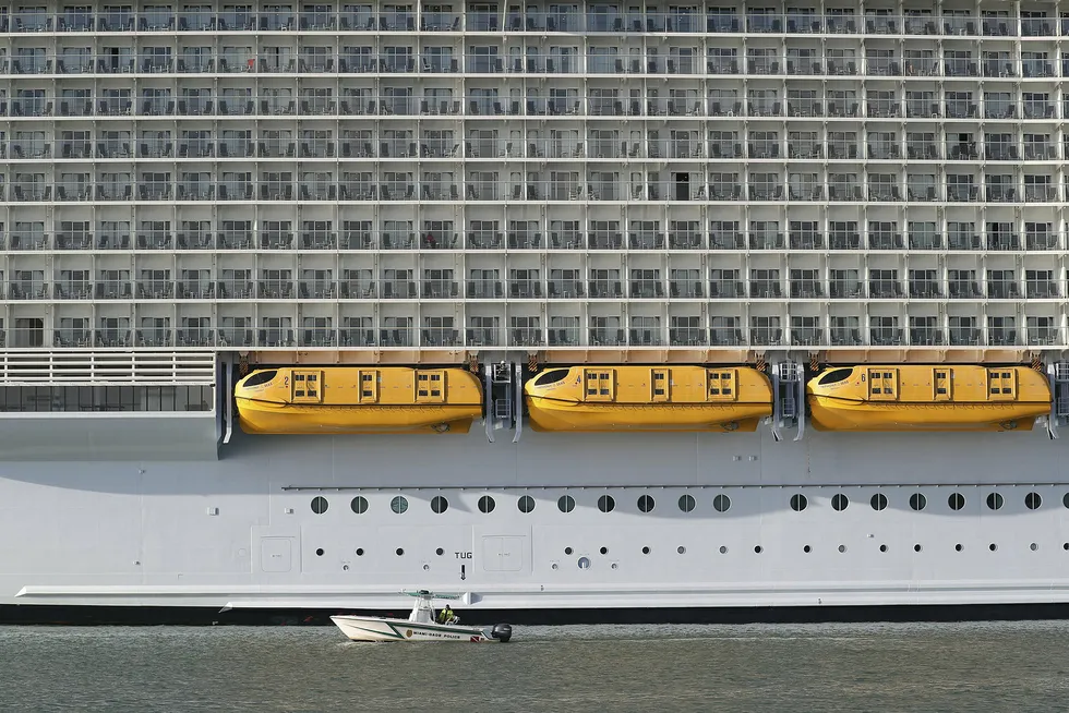 Her legger verdens største cruiseskip, «Symphony of the Seas» som tilhører Royal Caribbean Cruises, til kai 14. mars i Port Miami mens en patruljebåt kjører forbi.