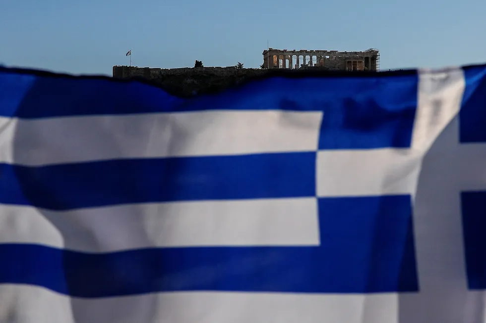 Eyes on LNG: Greek national flag flutters as the ancient Parthenon temple is seen atop the Acropolis hill, in Athens