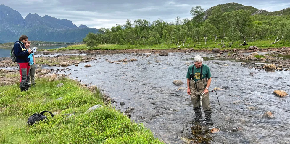 Befaring av Vaterfjord-vassdraget i Vågan kommune i Lofoten: Akvaplan-nivas Geir Dahl-Hansen står uti elva, flankert av kollega Eirik Henriksen (i rød bukse) og en grunneier.