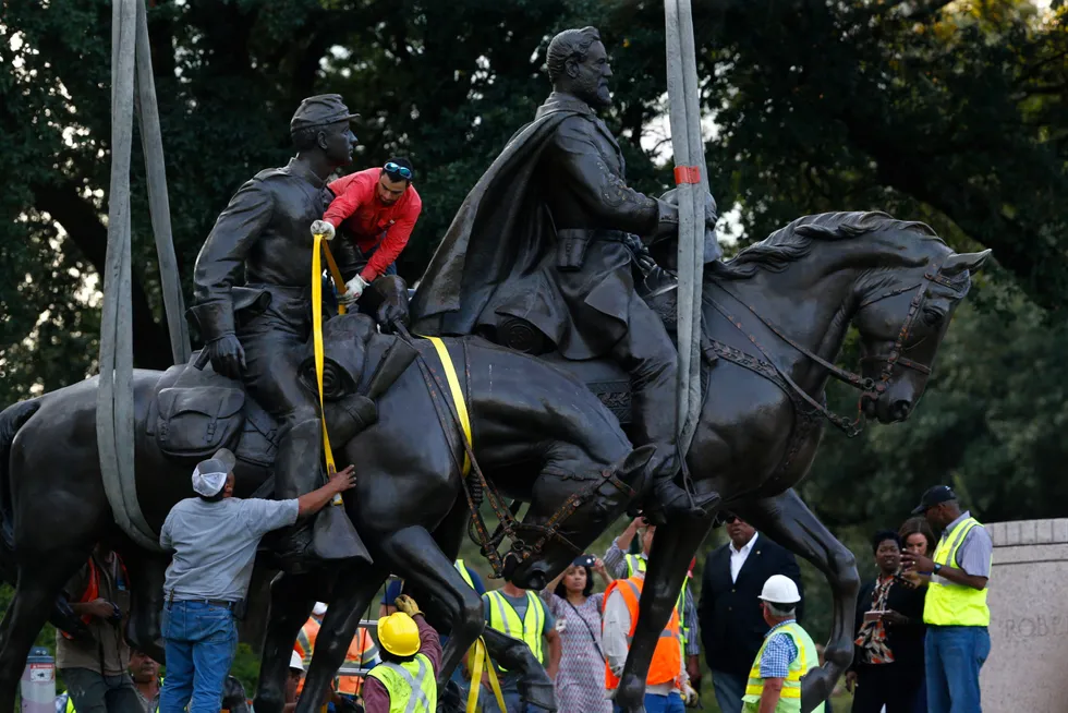 Exiled: Workers in 2017 prepare the Robert E. Lee statue for removal from a Dallas public park