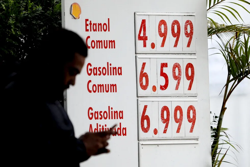 Counting: a consumer muses over prices at a petrol station in Sao Paulo, Brazil