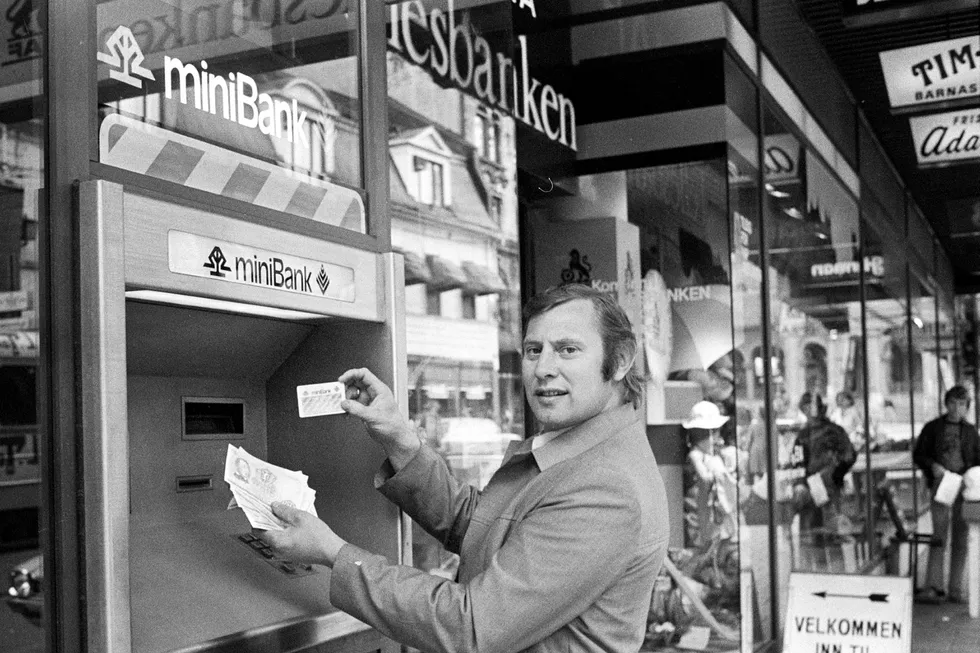 I juni 1978 ble de første minibankene montert i Norge. Kasserer Arvid Ramfjord demonstrerer terminalen utenfor Fellesbankens filial på NAF-huset i Oslo. Foto: Henrik Laurvik/NTB Scanpix