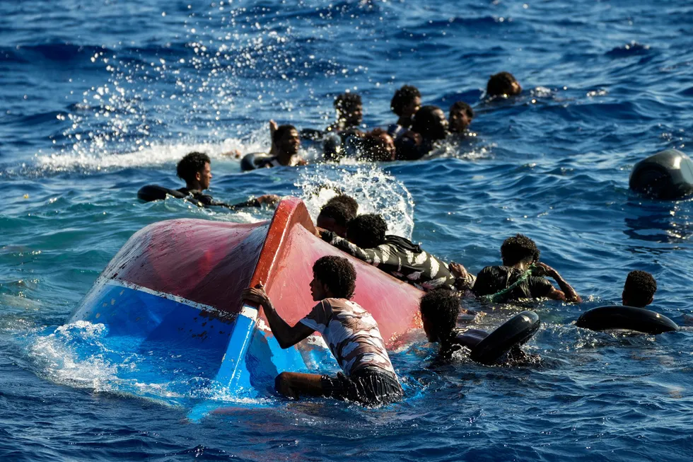 Migranter svømmer nær deres veltede båt ved den italienske øyen Lampedusa. EU strammer inn for at færre skal ta den farlige ferden.