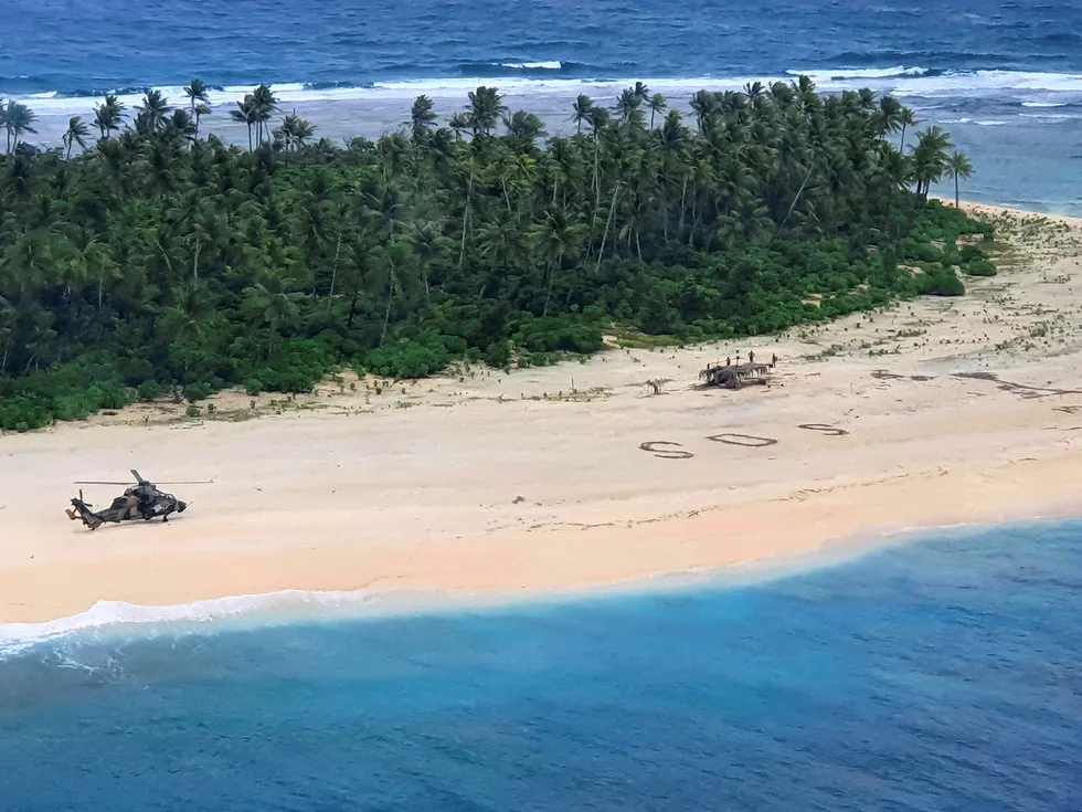 Et australsk helikopter landet på stranda der tre menn ble funnet etter å ha skriblet «SOS» i sanden.