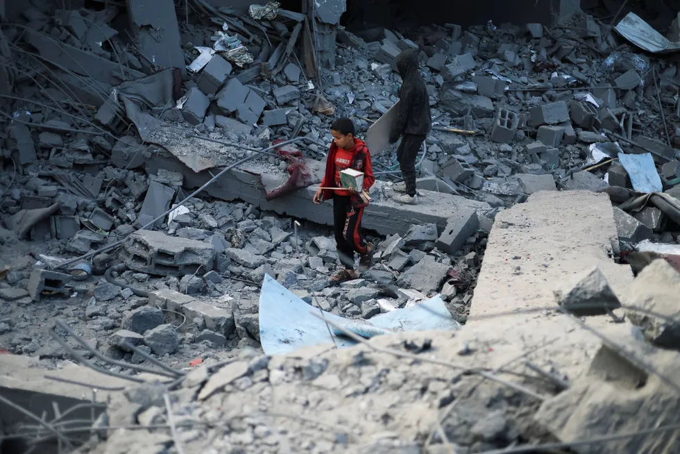 Palestinske barn inspiserer skadene etter israelske angrep mot en moske og hus i Rafah før helgen.