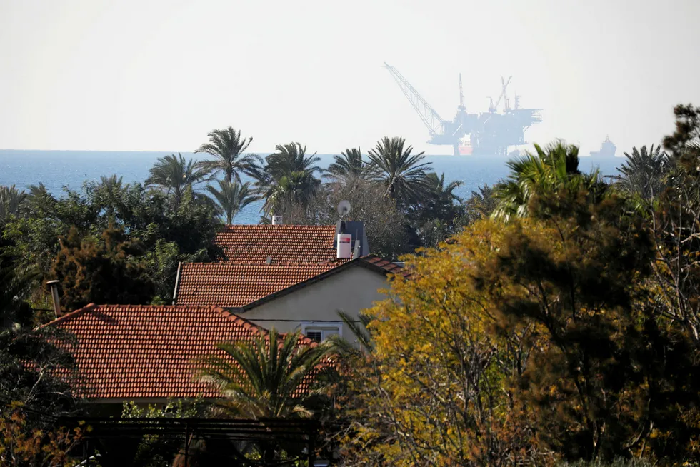 Injunction: houses in Kibbutz Nahsholim with the production platform of Leviathan natural gas field in the Mediterranean Sea in the background in northern Israel