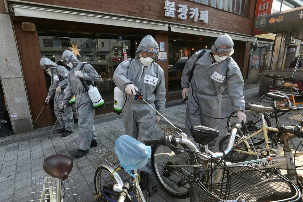 Sørkoreanske soldater sprayer desinfeksjonsmiddel mot det nye koronaviruset på en gate i Seoul i Sør-Korea fredag formiddag. Over 6200 mennesker er smittet i Sør-Korea.