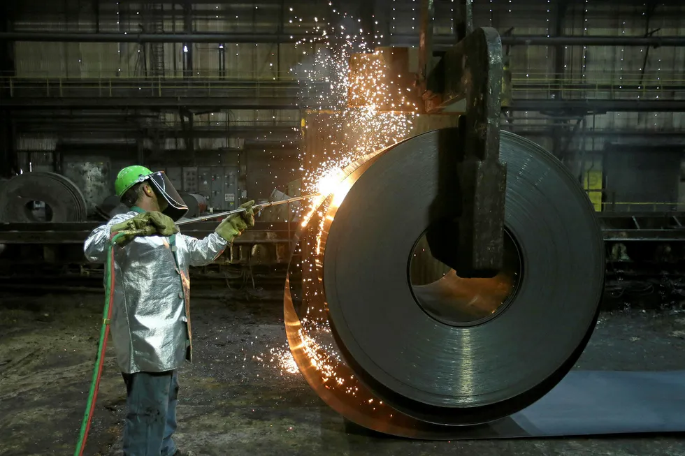 Burning issue: a worker cuts a piece from a steel coil at a mill in Pennsylvania, US