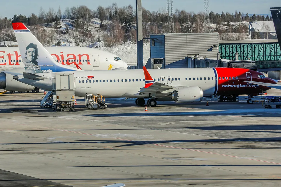 Et Boeing 737 MAX 8 fly fra Norwegian står ved gaten på Oslo lufthavn. Bak står et Boeing 777-260 (ET-ANP) fra Ethiopian Airlines.