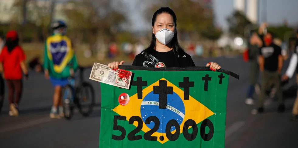 A woman holding a signal with the Brazilian flag takes part in a demonstration against the Brazilian President Jair Bolsonaro's handling of the COVID-19 pandemic in Brasilia, on July 3, 2021.