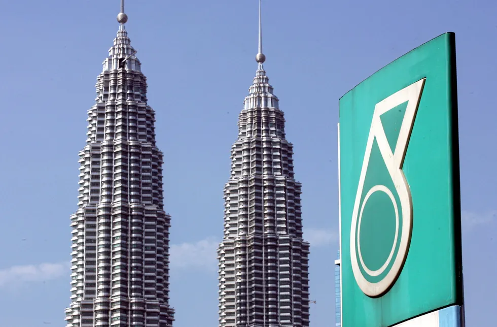 Headquarters: the Petronas twin towers is seen behind the company's corporate logo in downtown Kuala Lumpur.