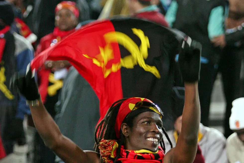 Flag day nears: An Angolan fan waves the country's flag before a soccer match.