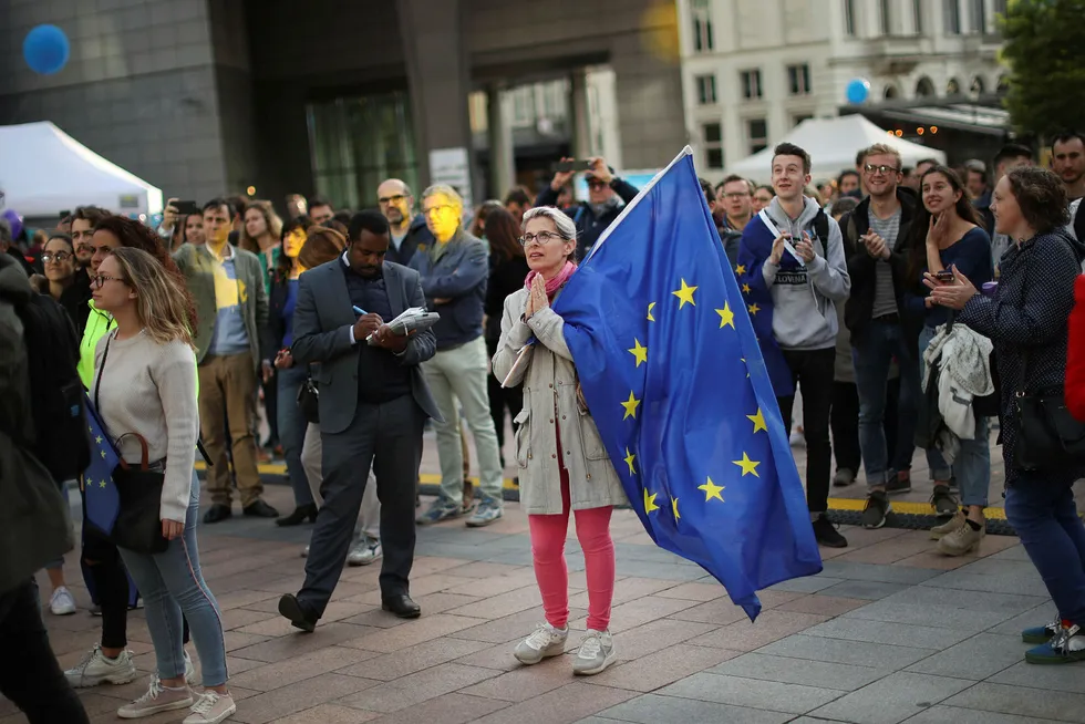 En kvinne holder et EU-flagg utenfor Europaparlamentet i Brussel.