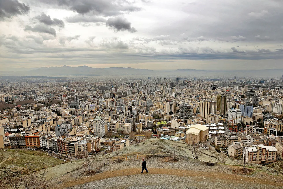 Outlook: a man walks on a hill overlooking Iran's capital, Tehran