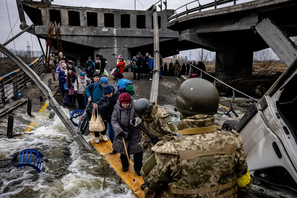 Krigen i Ukraina og mulig boikott av russisk olje sender olje- og gassprisene til værs. På bildet ser vi flyktninger fra Irpin i det nordvestliges Ukraina som krysser en ødelagt bro,
