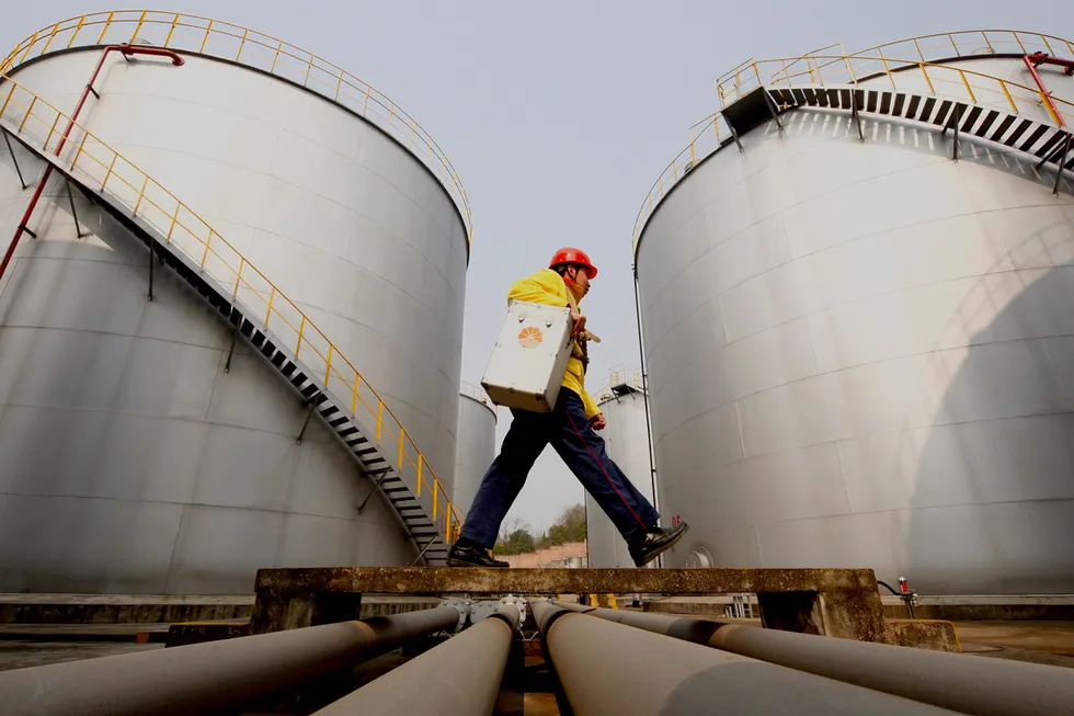 Releasing reserves: a worker walks past tanks at a Petrochina storage base in Suining, in south-west China's Sichuan province