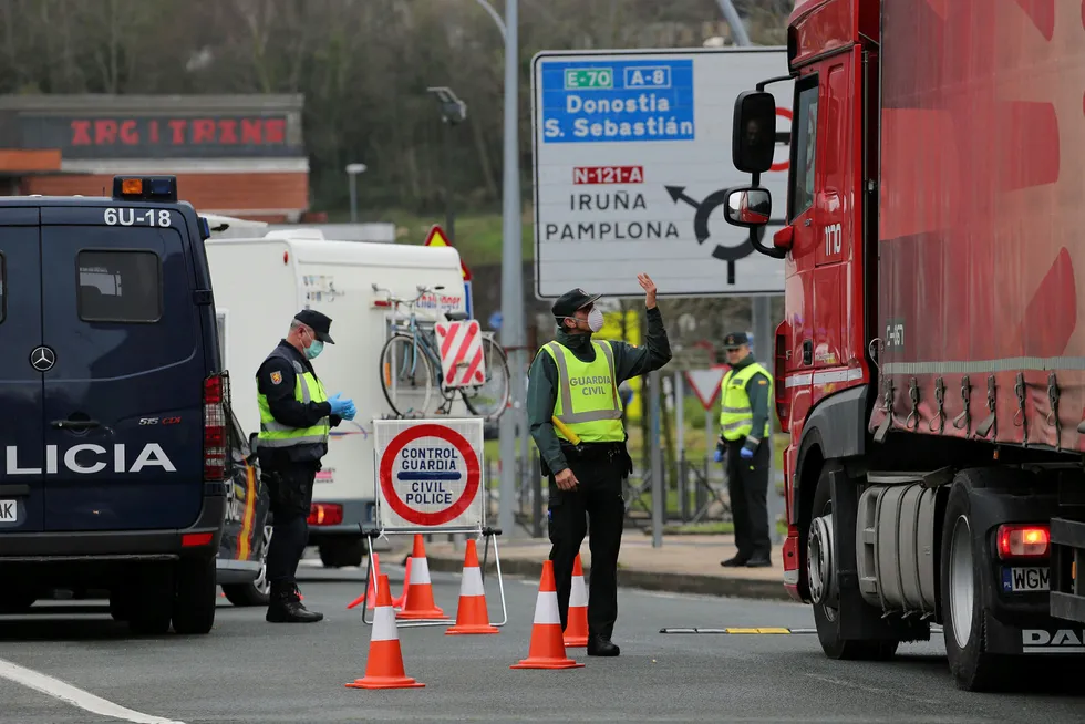 Maskerte spanske Guardia Civil og politi sjekker lastebiler som vil inn i Spania fra Frankrike. Strenge restriksjoner på grensepasseringer er innført over hele Europa.