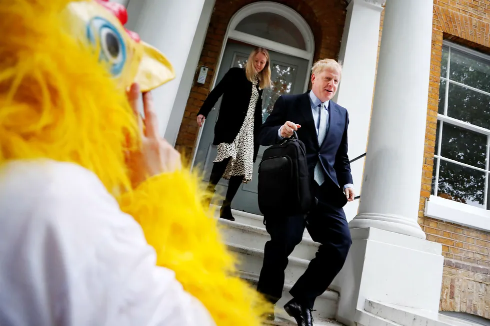 A person dressed as a chicken stands outside as British Conservative Party lawmaker Boris Johnson leaves his home in London, Thursday, June 13, 2019. Boris Johnson, who ran London as mayor for eight years until 2016 and then became Britain's foreign secretary until his resignation last summer, is a confident if erratic Conservative Party star with a simple message: I'll sort out Brexit. (AP Photo/Frank Augstein) ---