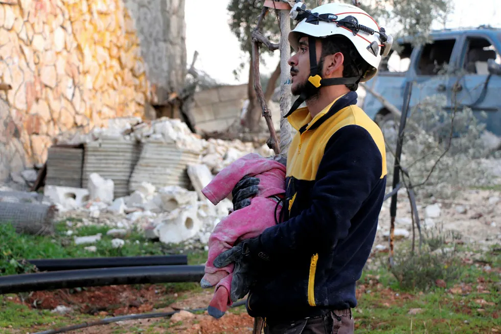 En hjelpearbeider fra sivilforsvarsgruppen De hvite hjelmene hentet torsdag formiddag ut et lite barn blant ofrene fra et russisk flyangrep i utkanten av den opprørskontrollerte landsbyen Maaret Musreen nordvest i Syria.