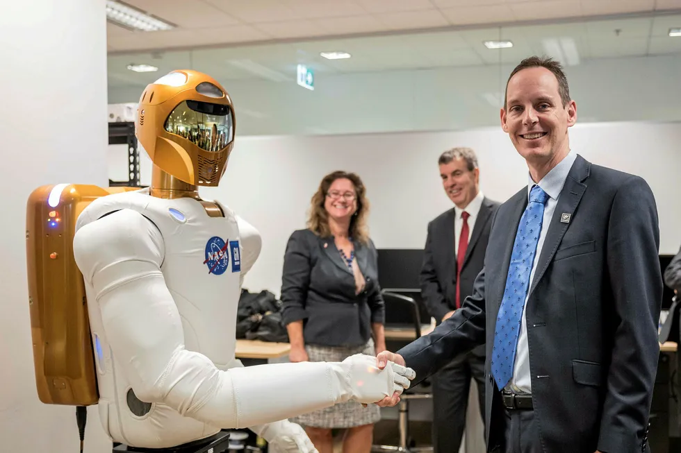 Collaboration: Woodside chief technology officer Shaun Gregory shakes hands with NASA's Robonaut which the Australian company has on loan for the next 60 months