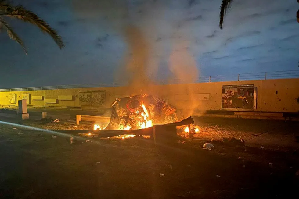 Rising tension: burning debris are seen on a road near Baghdad International Airport, which according to Iraqi paramilitary groups were caused by three rockets hitting the airport in Iraq