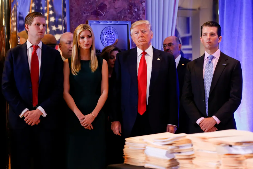 Donald Trump omgitt av tre av sine barn. Det er Donald Trump jr. (til høyre) og Ivanka Trump som er blitt stevnet sammen med faren. Helt til venstre er Eric Trump.