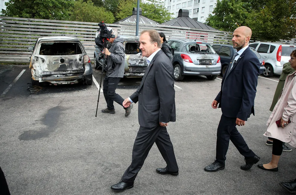 Sveriges statsminister Stefan Löfven (t.v.) på Frölunda torg i Göteborg etter mandagens mange påsatte bilbranner i byen.