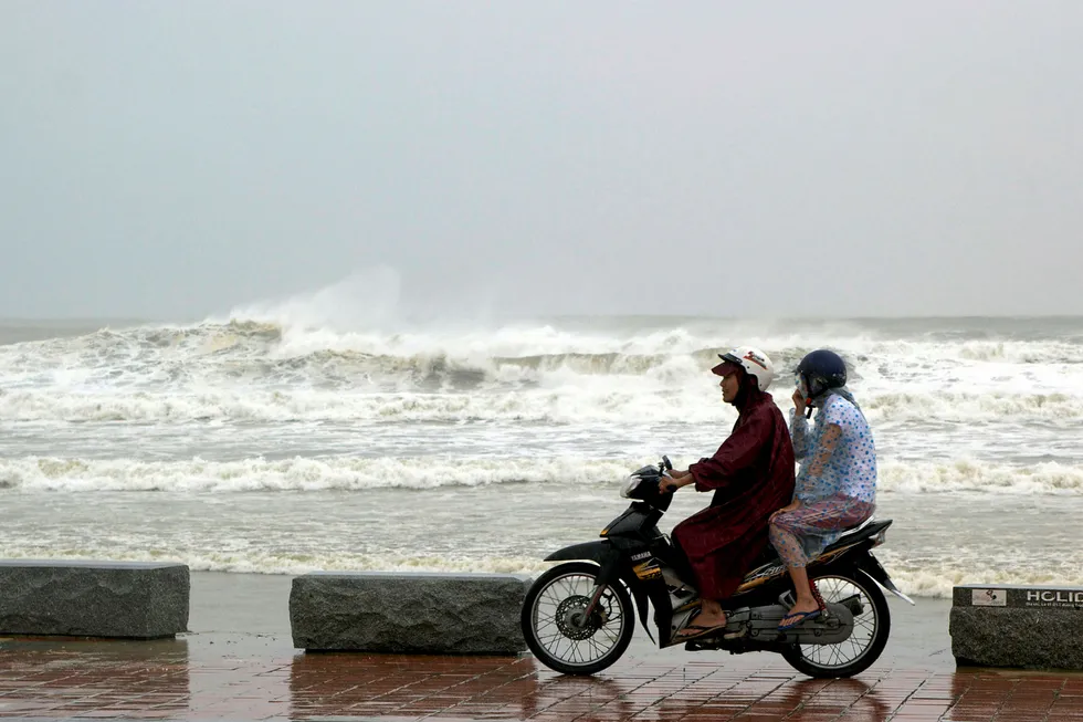 Troubled waters: people ride a motorbike next to the beach in Danang, Vietnam
