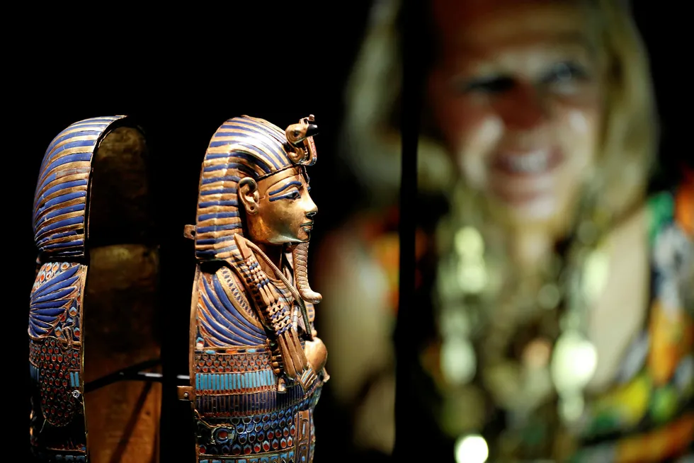 a woman looks at miniature canopic coffin at the Tutankhamun exhibition