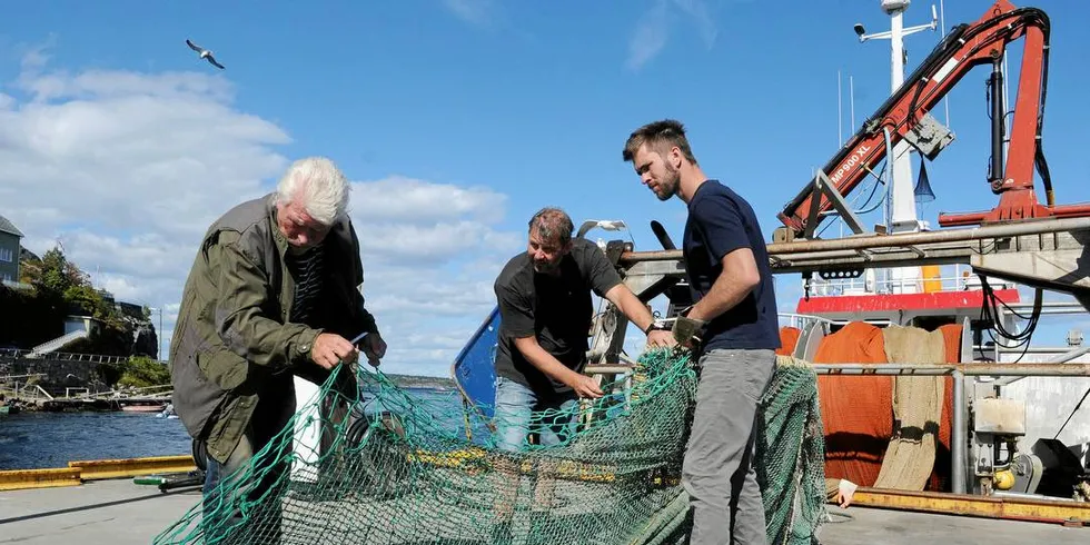 FIKSEFISKER: Reketråleren «Ero» av Risør har fått trøbbel med fiskerista. Mannskap Oskar Haldorsson (t.h.) og skipper Geir Jørgensen får hjelp av tidligere eier Erling Anfinnes (t.v.).Foto: Kjersti Kvile