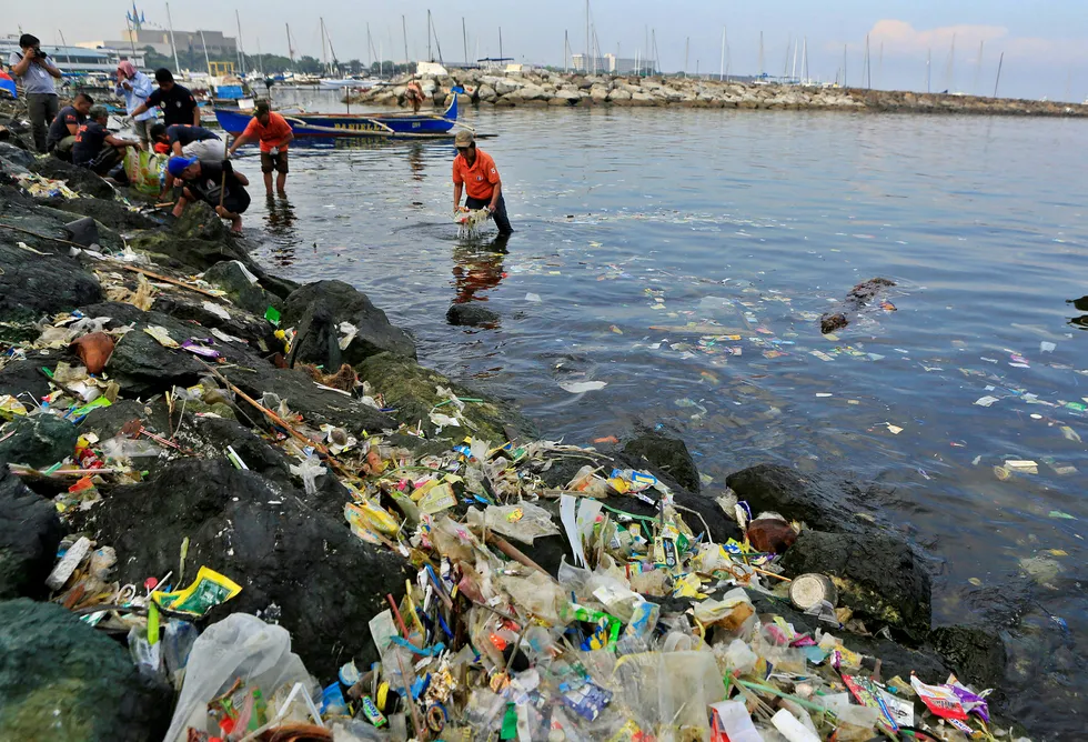 Statlig ansatte plukker og sorterer plast som har skyldt opp på strendene i Manila i Filippinene. Det største bidraget til plast i havet kommer med elver ut i sjøen. Foto: Romeo Ranoco/Reuters/NTB Scanpix
