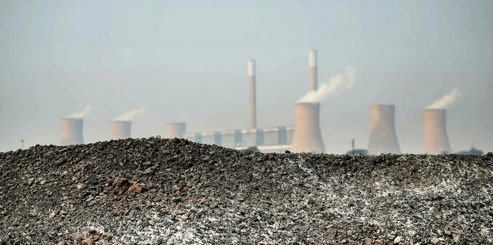 This photo taken on September 28, 2016 on the outskirts of Witbank shows a pile of coal in front of the coal-fired Duvah power plant.