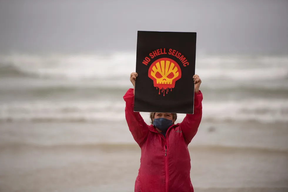 Protest: In this photo taken on 5 December 2021, a woman holds a placard on Muizenberg beach, Cape Town in South Africa, protesting against plans by the supermajor to shoot marine seismic offshore the Wild Coast and in Algoa Bay