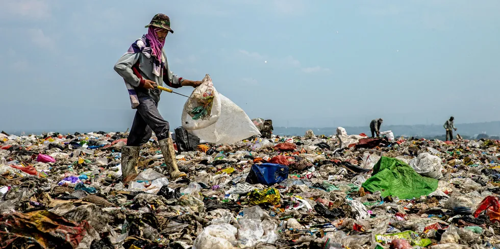 People searching for recyclable plastic waste at a rubbish dump.