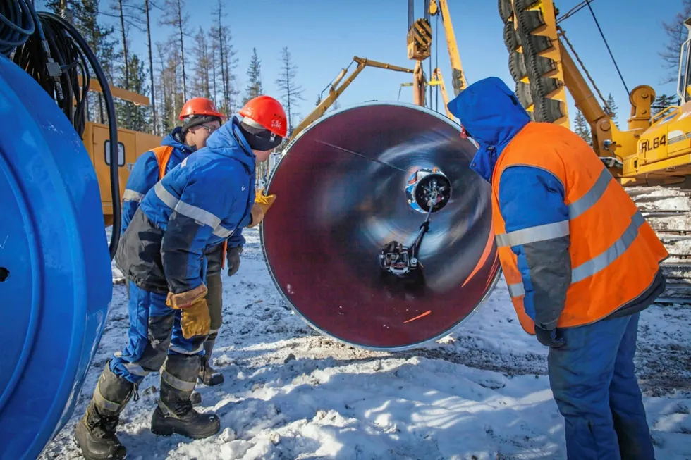 Closure: workers inspect a pipe during the construction of gas export pipeline Sila Sibiri in East Siberia in Russia