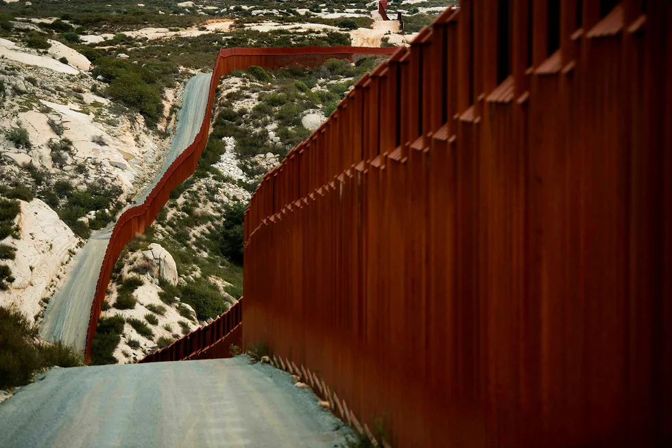 En rekke selskaper som har lagt inn anbud på bygging av mur mellom USA og Mexico skal ha fått 30 dager på seg til å bygge en prototyp av sine desigforslag. Bildet viser deler av muren mellom de to landene i Tecate i California. Foto: Jim Watson/Afp photo/NTB scanpix