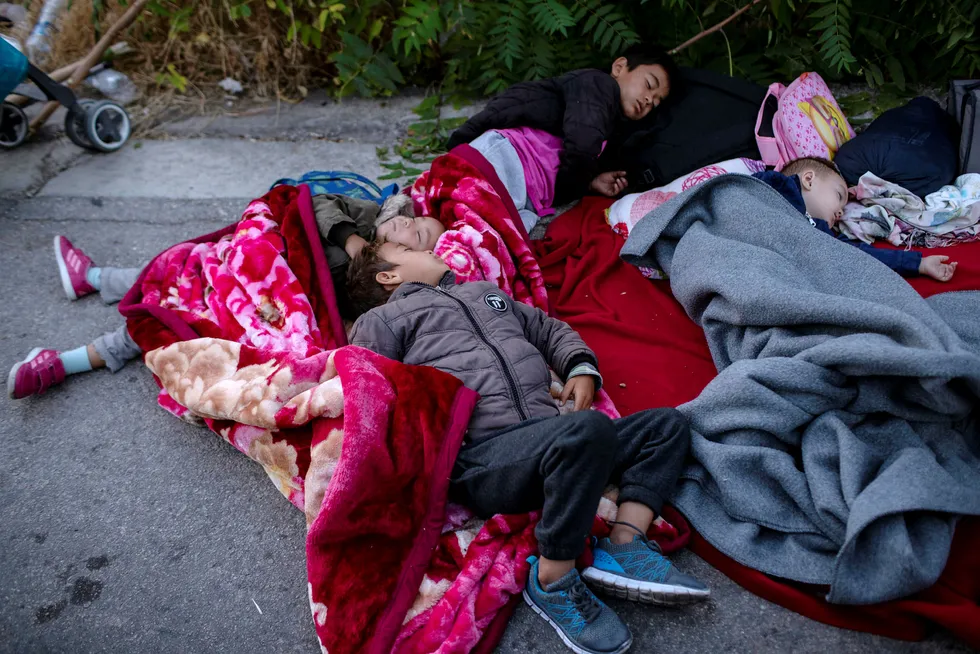 Children sleep on the road near the fire-destroyed Moria refugee and migrant camp on the island of Lesbos, Greece, Thursday, Sept. 10, 2020. A second fire in Greece's notoriously overcrowded Moria refugee camp destroyed nearly everything leaving thousands more people in need of emergency housing. (AP Photo/Petros Giannakouris) ---