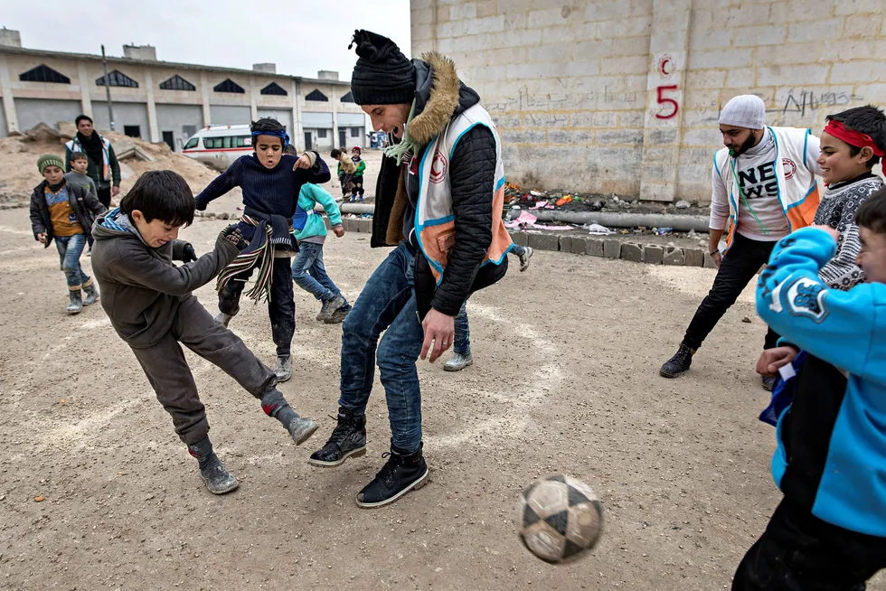 De siste årene har vært preget av utenrikspolitisk uro, men nå er optimismen på vei tilbake. Her spiller frivillige fotball med barna i flyktningeleiren Jibrin i Syria. Foto: Aleksander Nordahl