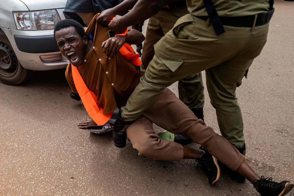 Ugandan police officers detain an environmental activist taking part in a protest against the East African Crude Oil Pipeline (EACOP) project, to transport oil from the TotalEnergies' Tilenga project, in the country's capital of Kampala in August 2024.