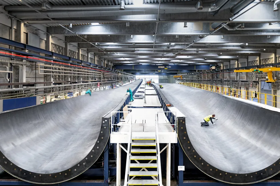 An employee of Europe-based Vestas performs final checks on a 15MW-V236 wind turbine blade mould at its factory in Nakskov, Denmark.