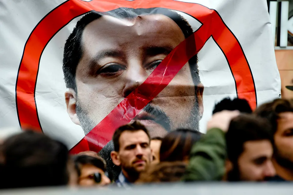 Demonstranter holder en plakat med bilde av Matteo Salvini, leder av partiet Ligaen, mens de protesterer under ministerens besøk til Napoli denne uken.